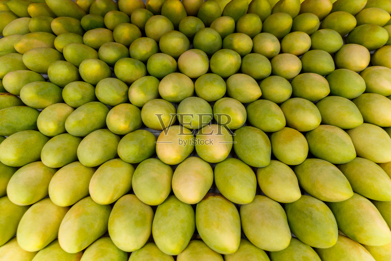 芒果的节日。和新鲜的黄色芒果一起站在街市上照片摄影图片