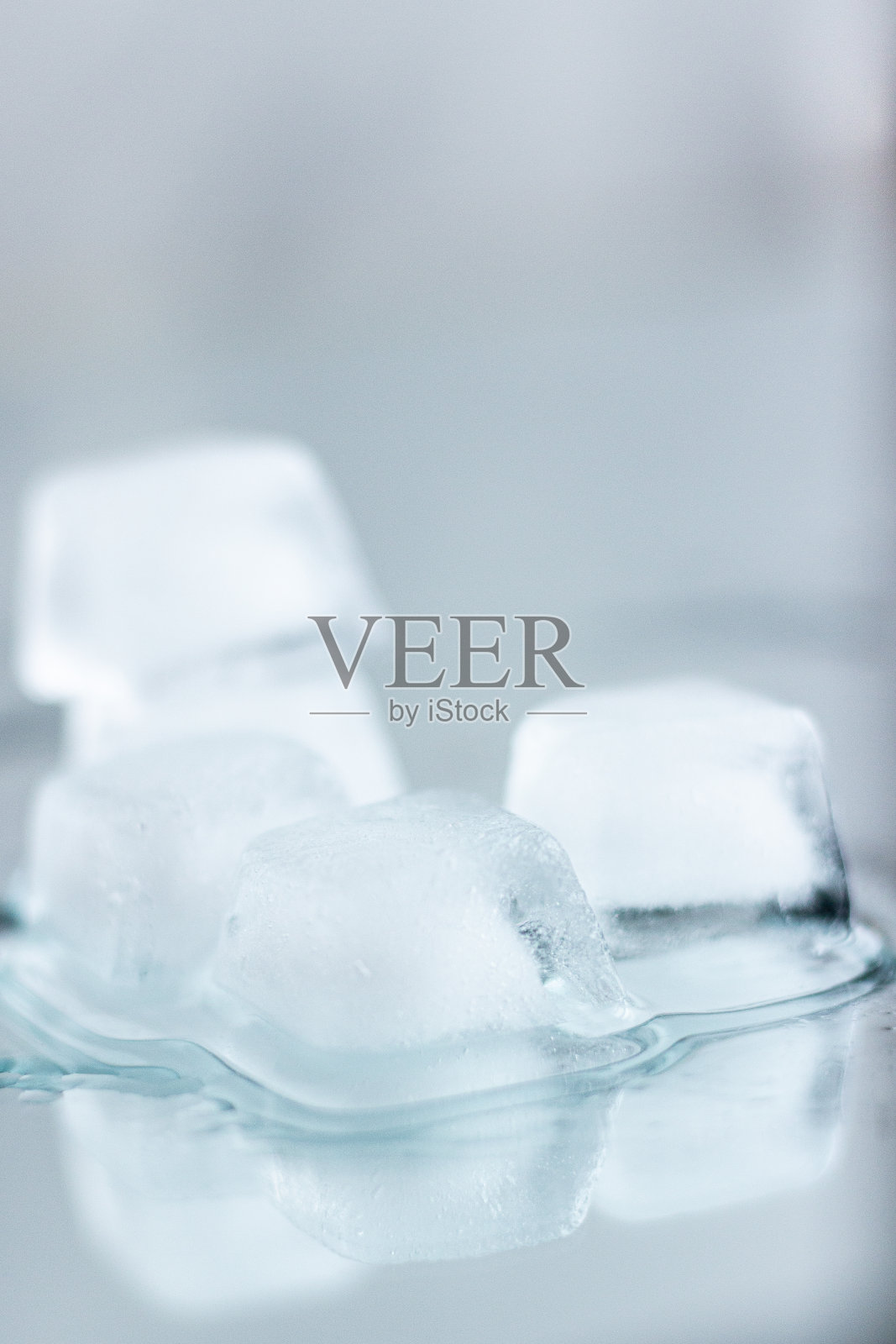 融化的冰块在浅色背景下照片摄影图片