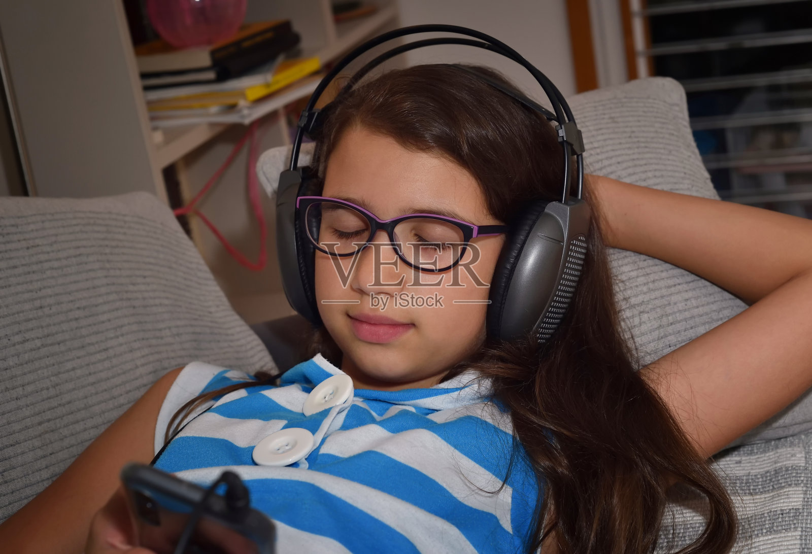 年轻女孩戴着耳机听音乐照片摄影图片