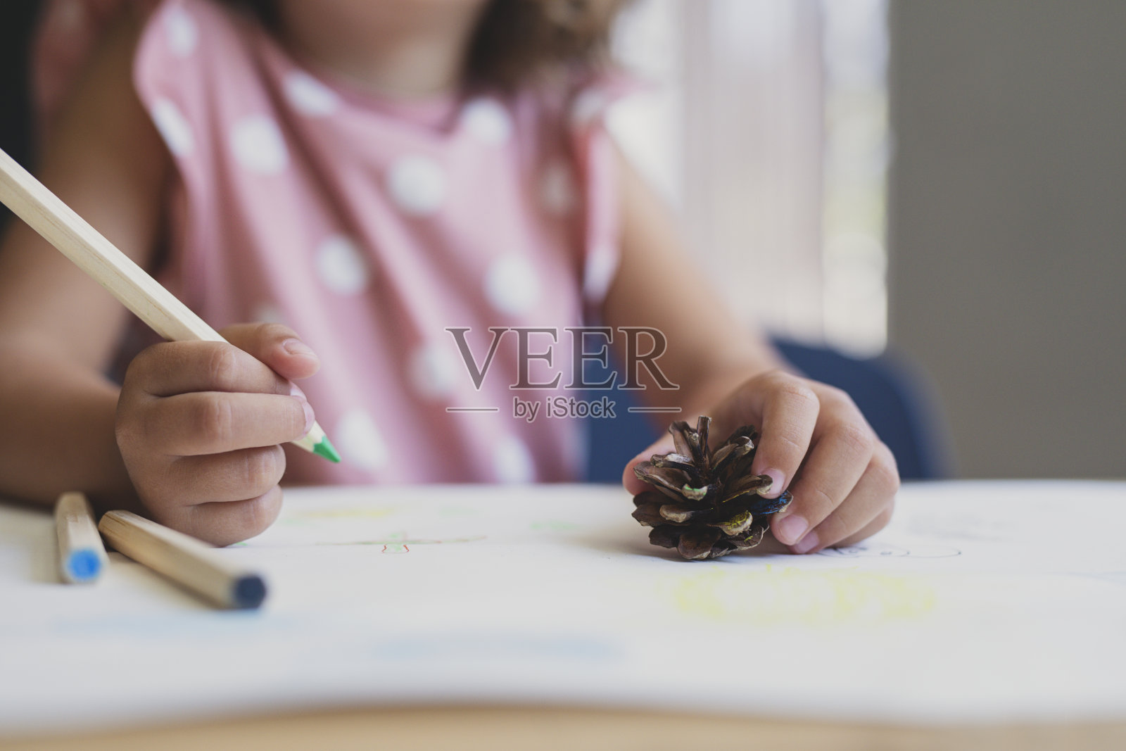 一个无名小女孩在客厅用彩色铅笔画橡子照片摄影图片