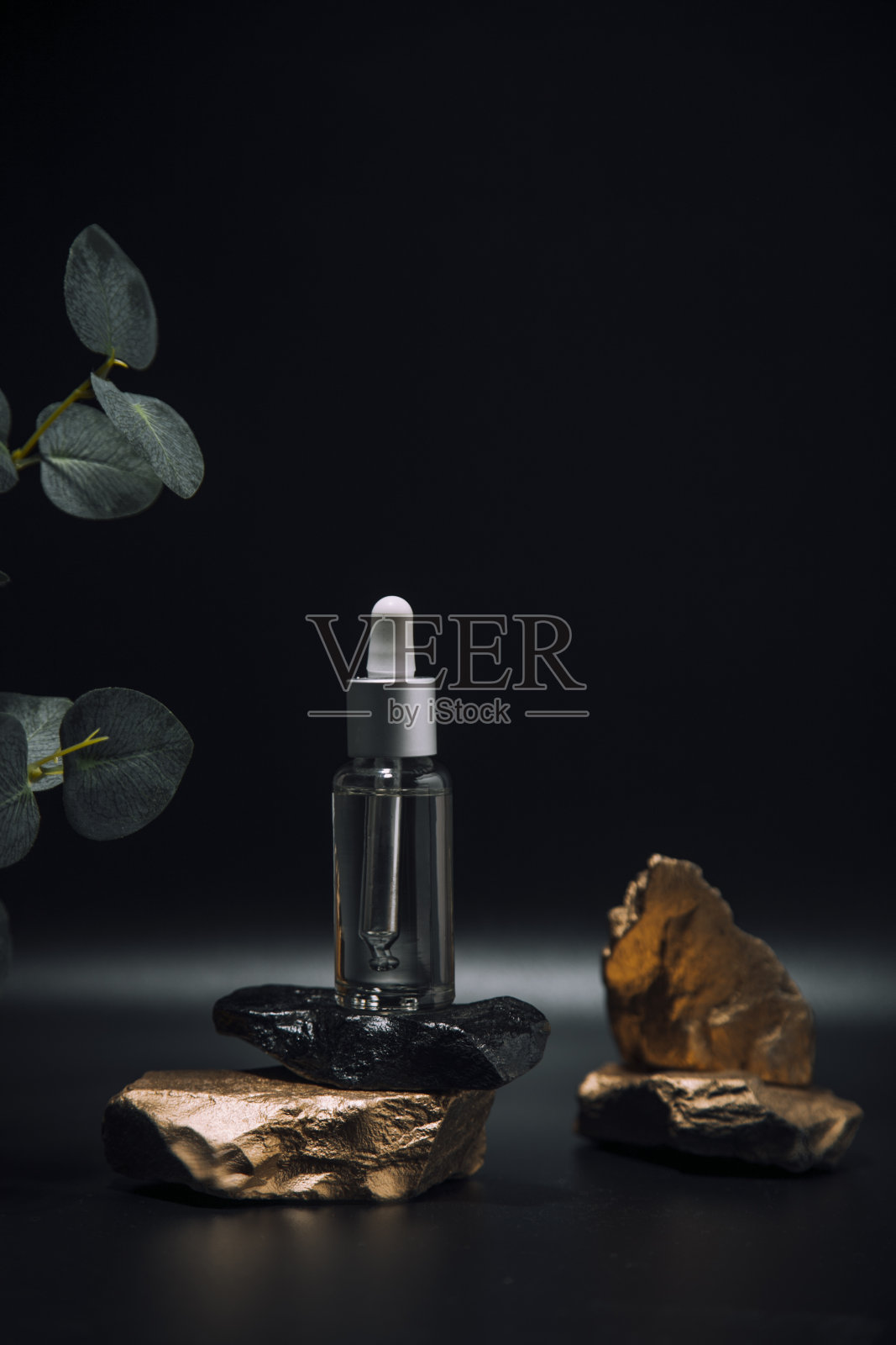 面部皮肤护理精油。石头上有吸管的玻璃瓶。皮肤护理照片摄影图片