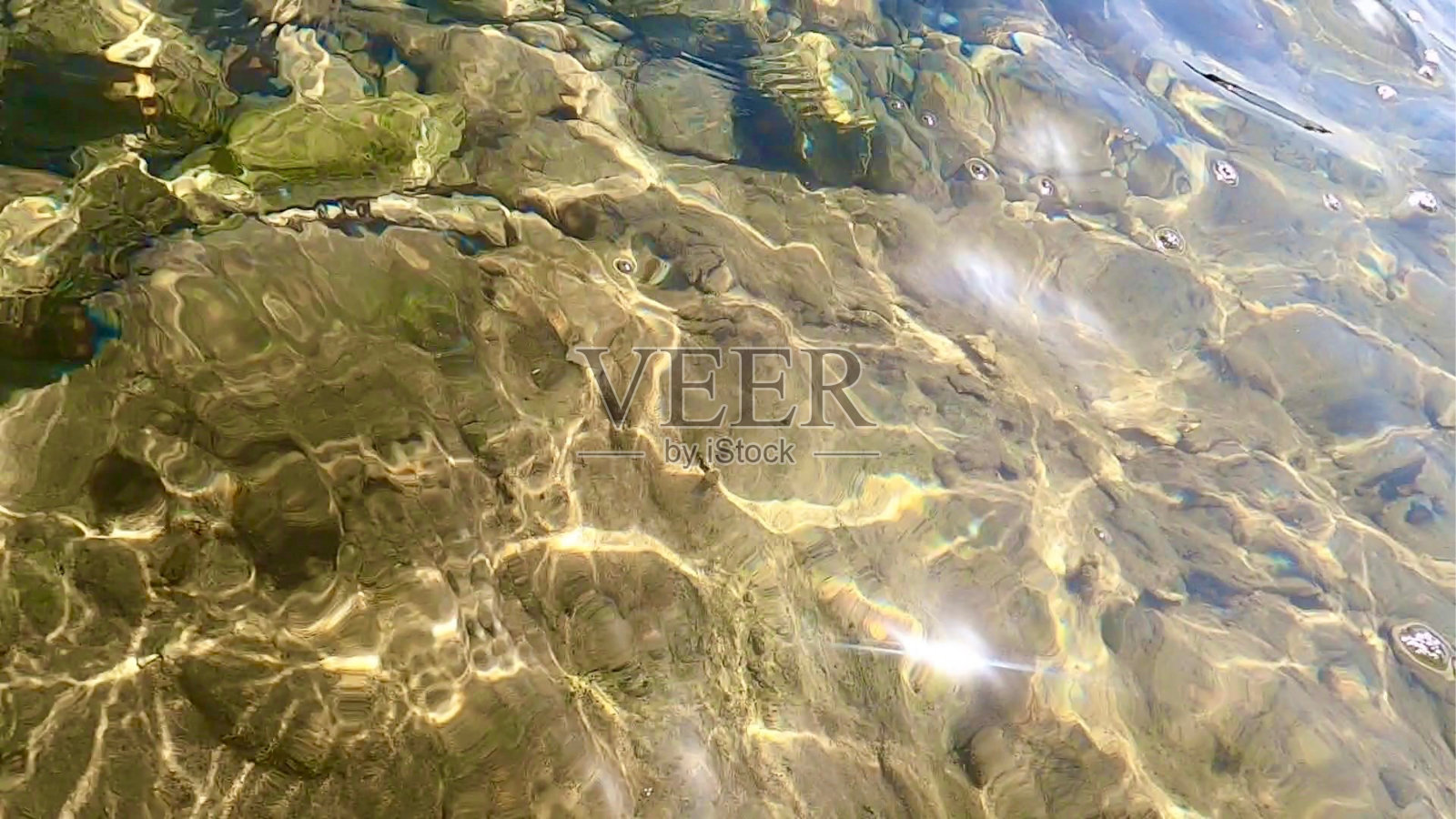 从水面背景反射的光线。在水下岩石上产生的折射图案。照片摄影图片