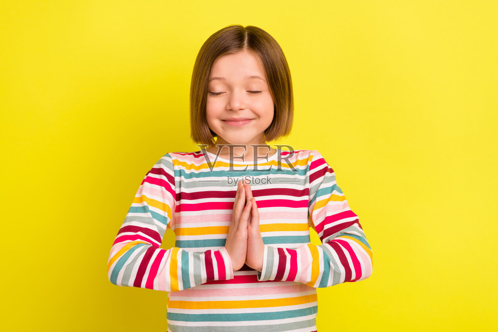 平静的小快乐快乐的积极女孩的手祈祷许愿现在孤立在亮黄色的背景上照片摄影图片