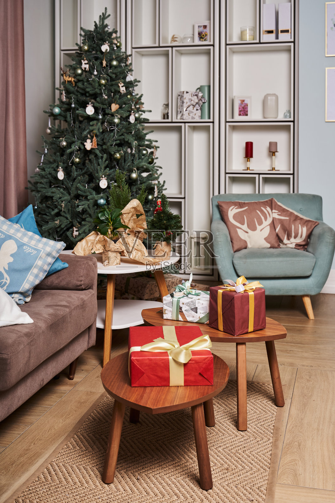 一个斯堪的纳维亚风格的房间,在角落里有一棵漂亮的圣诞树,桌子上放着几个装着礼物的盒子照片摄影图片