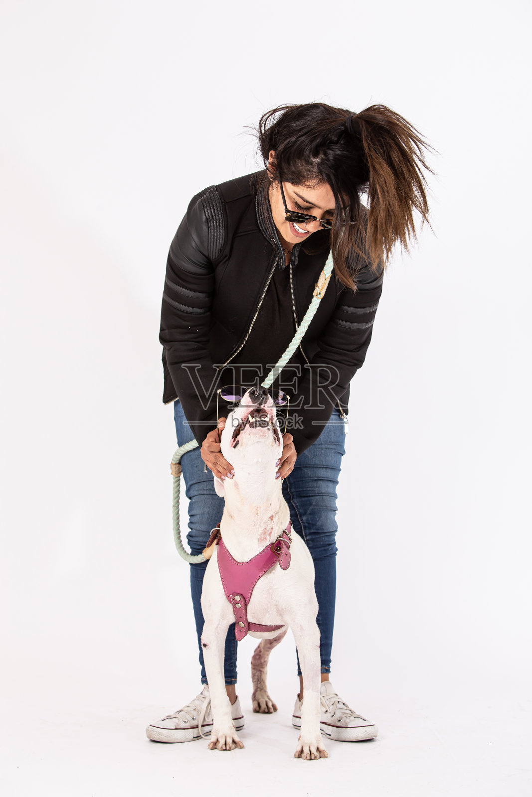 一个年轻的女人和她的斗牛犬。照片摄影图片