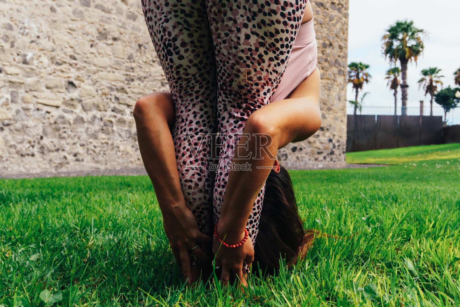 女人在公园草坪上练习瑜伽照片摄影图片