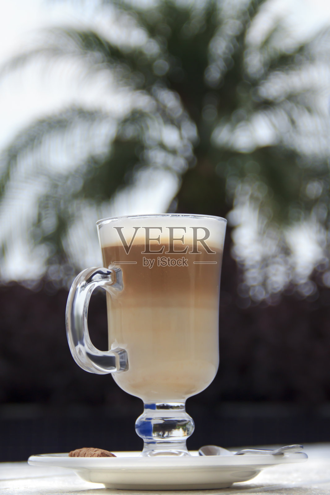 拿铁卡布奇诺,棕榈树模糊的背景。照片摄影图片