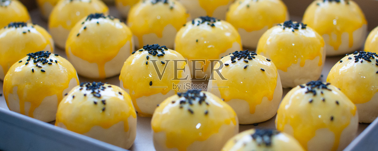 用芝麻裹着的蛋黄酥皮,烘烤前收起来,蛋黄酥皮是中国传统的糕点,由小麦、黄油、蛋黄等材料制成。照片摄影图片