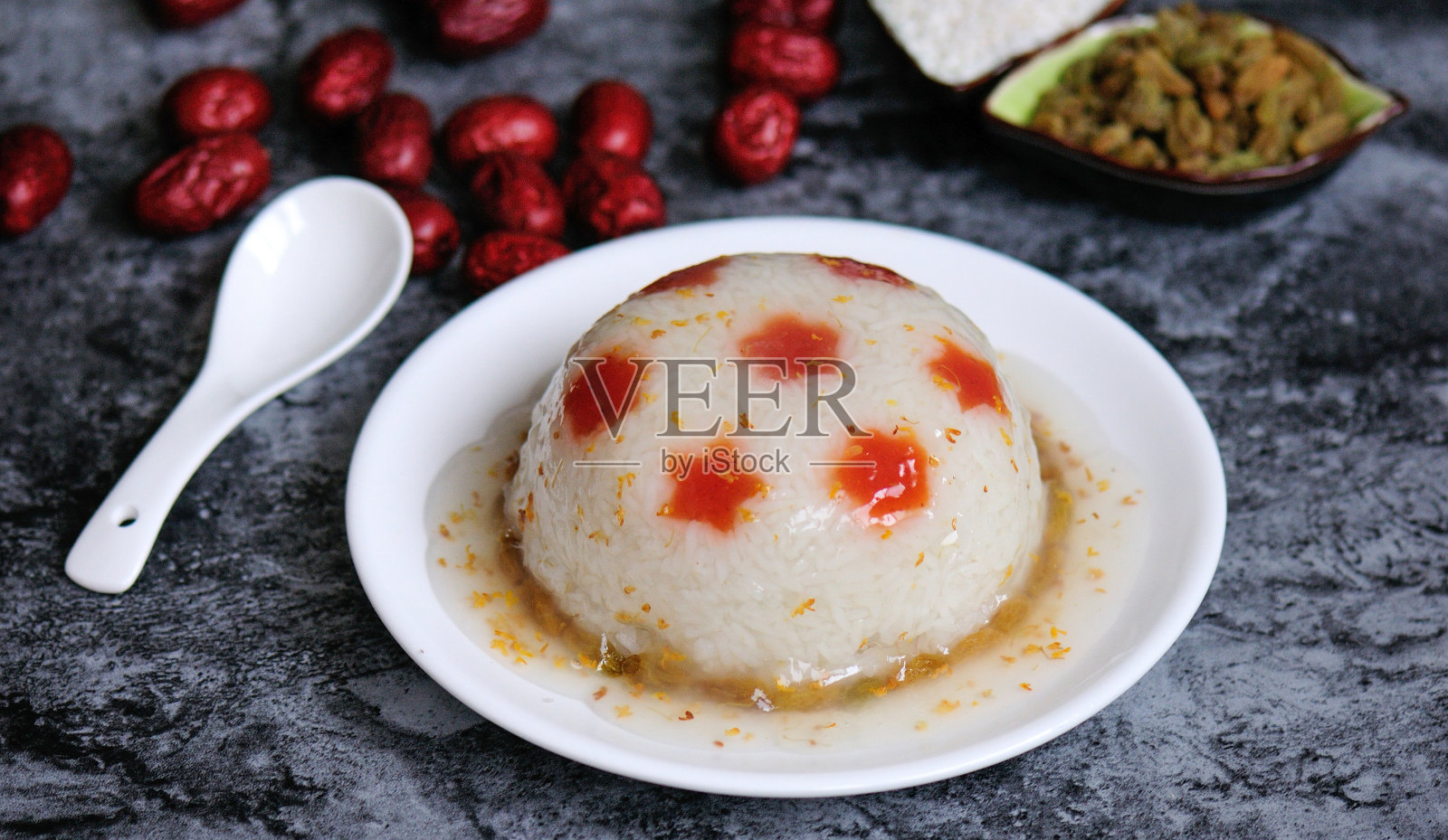 蒸糯米与枣和葡萄干灰色背景。照片摄影图片