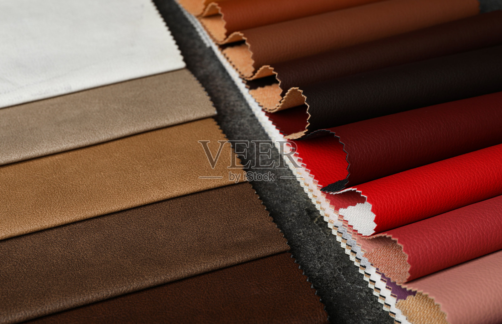 灰色石头背景上的皮革样品,特写照片摄影图片