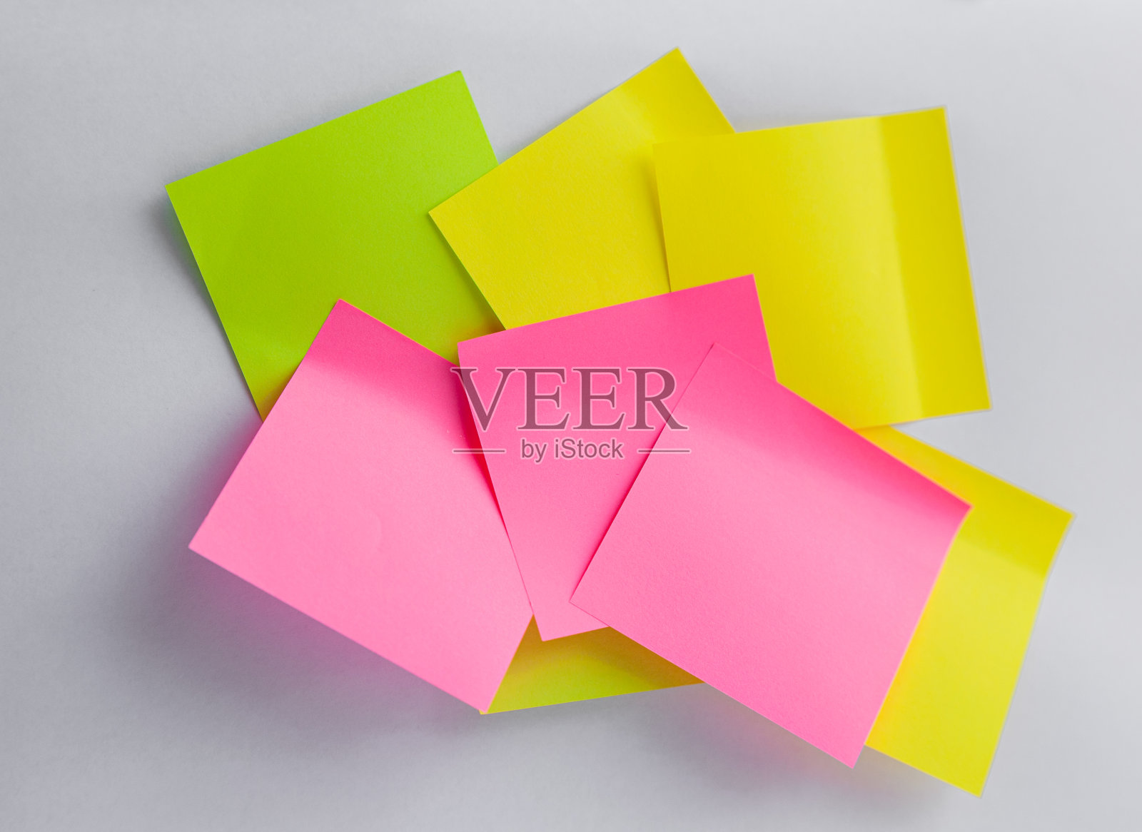 黄色,绿色,粉色的便利贴在白色的背景上。色纸。回到学校的最小概念照片摄影图片