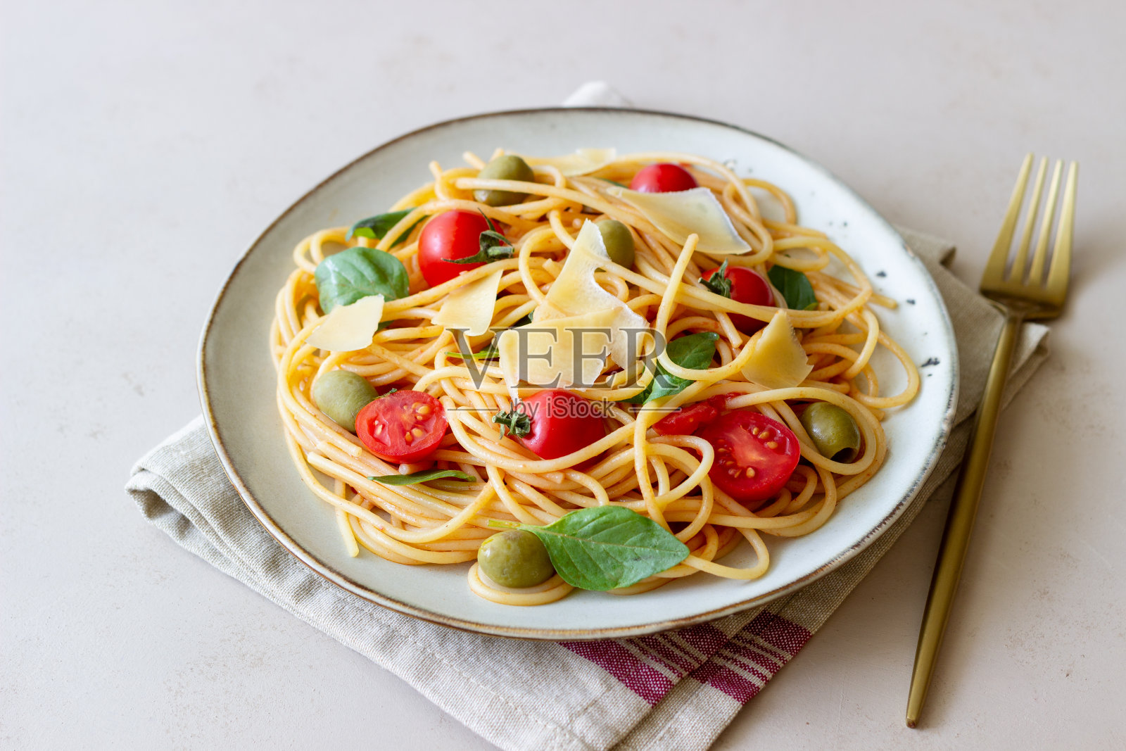 意大利通心粉,番茄,罗勒,橄榄和帕尔马干酪。健康饮食。素食。照片摄影图片