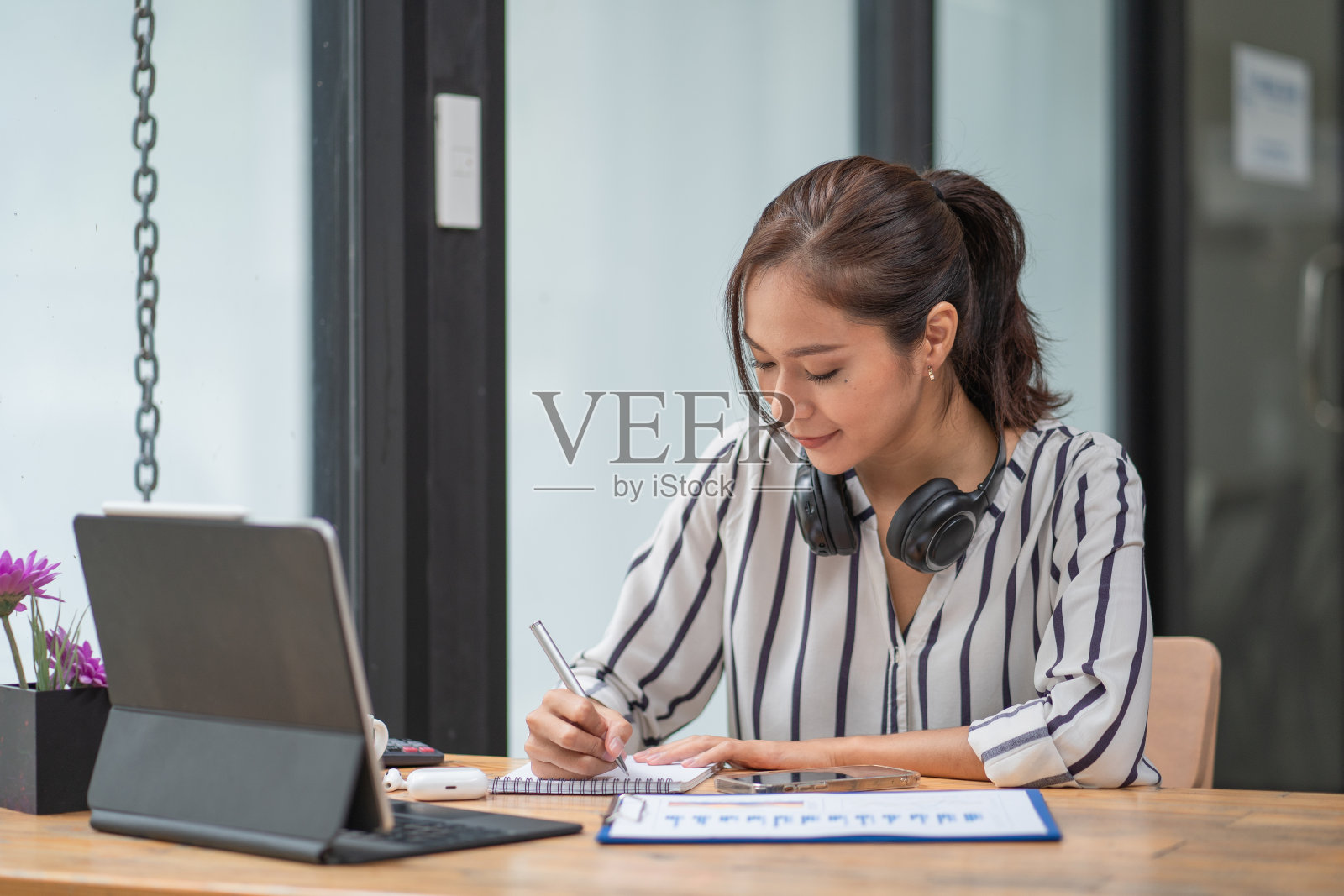 一个女商人一边在家工作一边用笔写字照片摄影图片