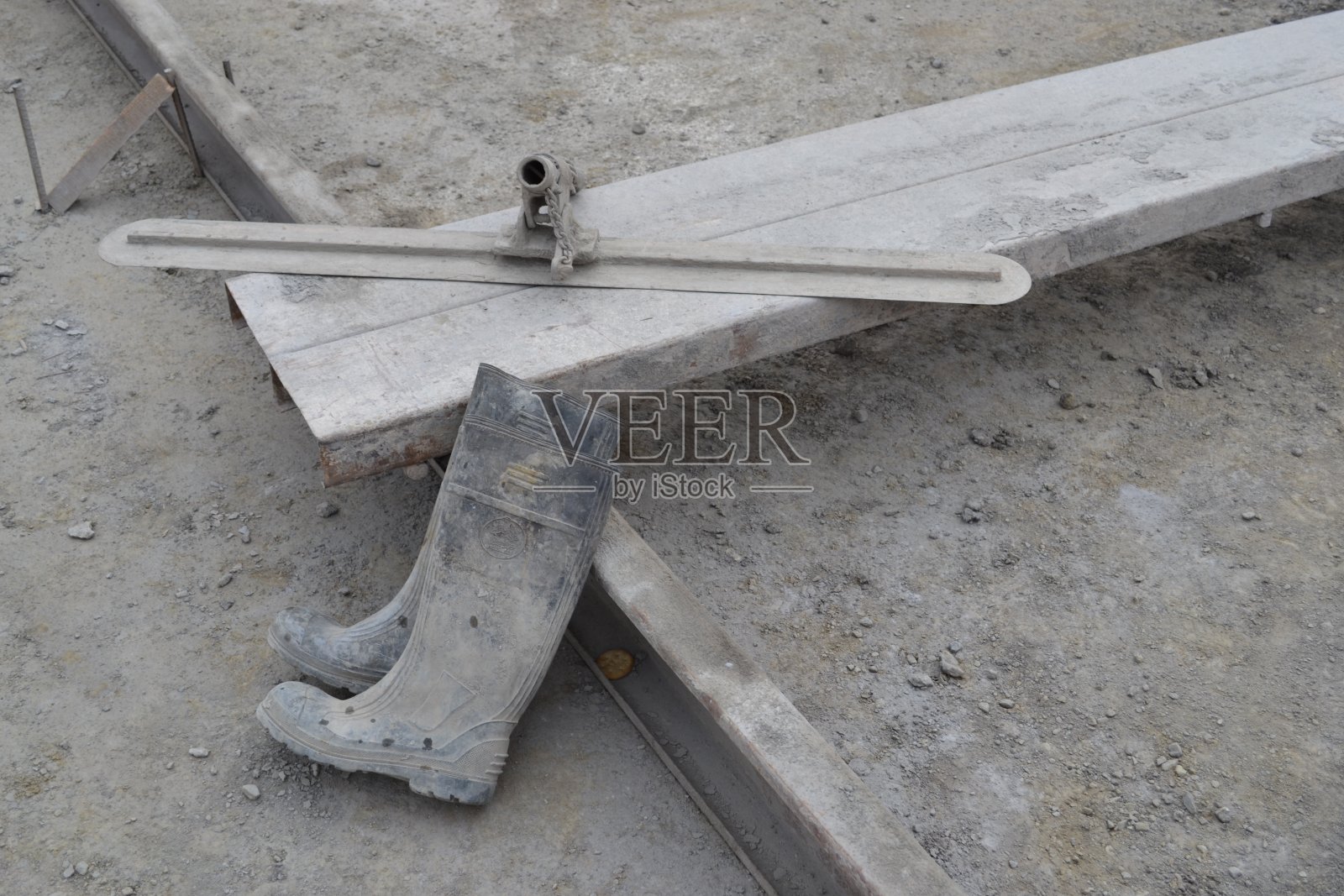 灰色木制施工模板、橡胶施工靴和完成浇筑混凝土的工具照片摄影图片