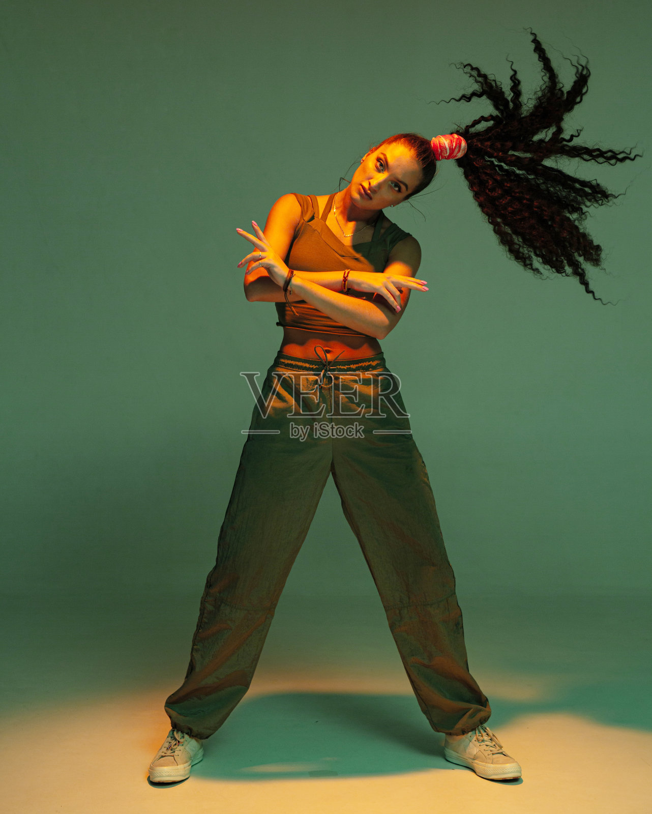 自信的年轻混血女孩,非洲式头发,尾端站在聚光灯下照片摄影图片