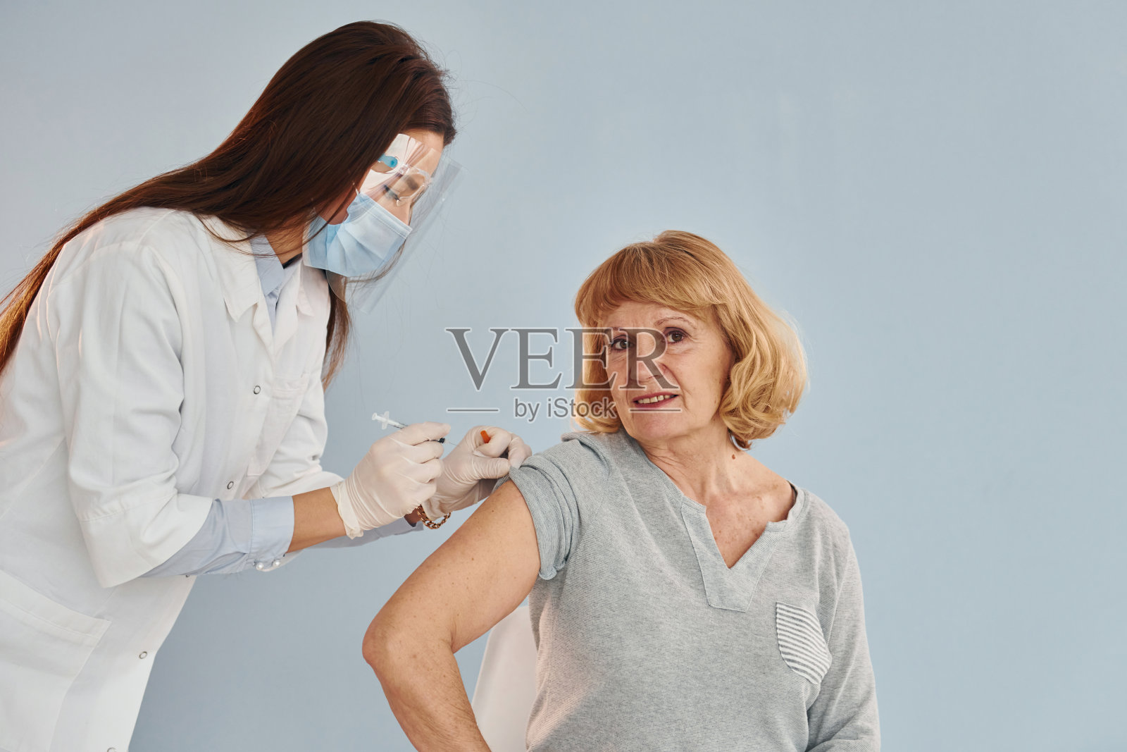 年轻女医生正在医院给老年妇女打针照片摄影图片