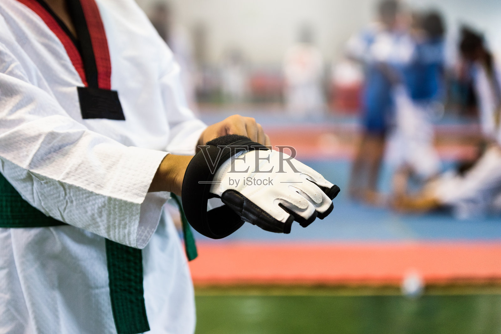 跆拳道战斗机手套。跆拳道运动员的孩子。运动员在跆拳道比赛中热身和打击对手的时刻照片摄影图片