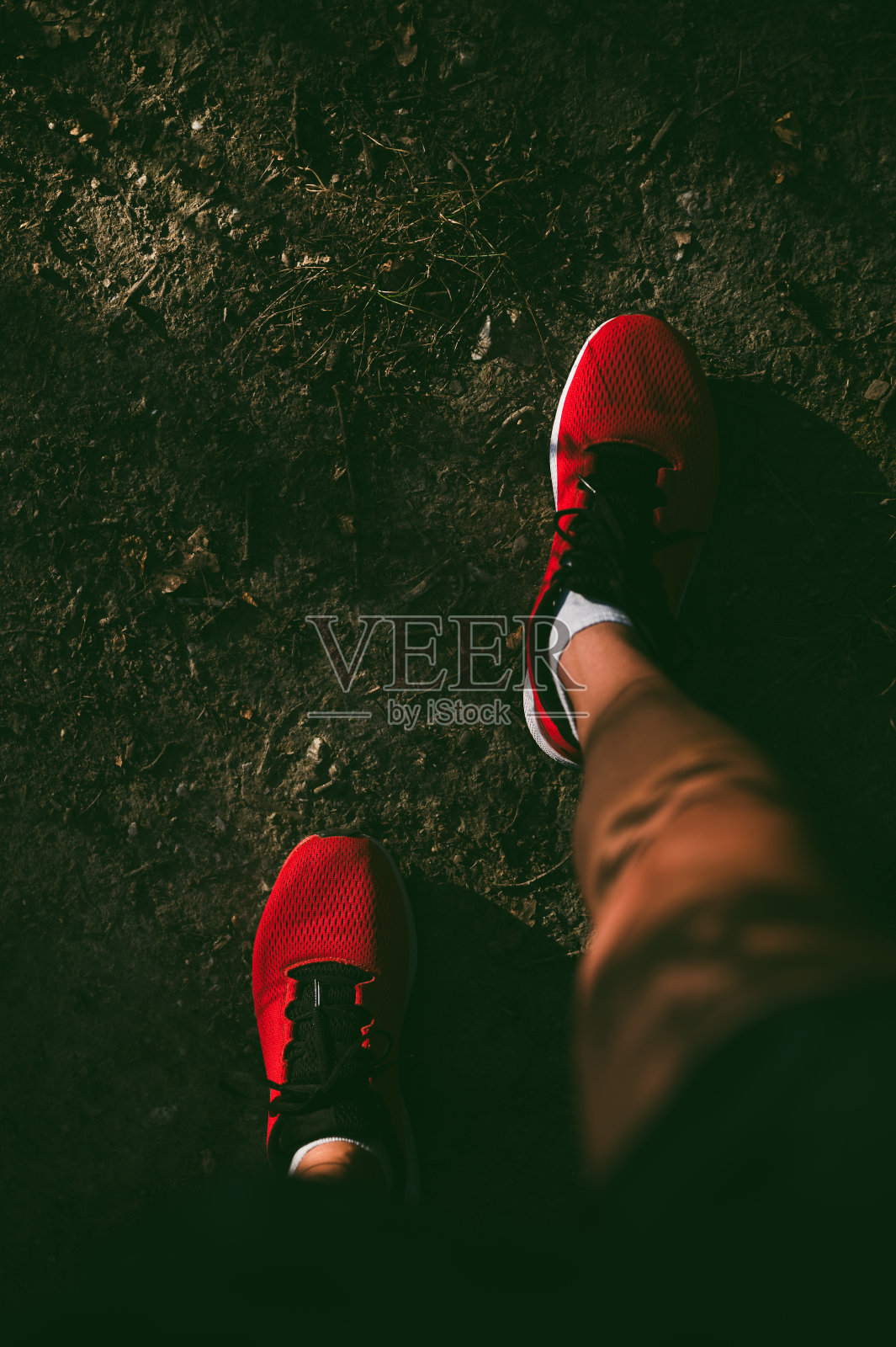 俯视图在红色运动鞋上的男性的脚站在土路照片摄影图片