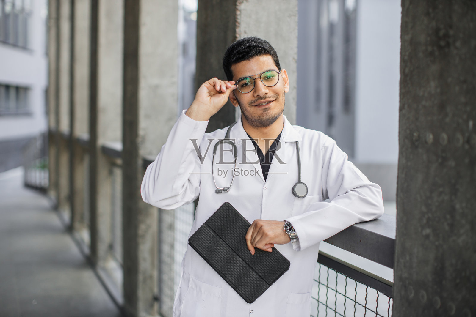 户外:可爱的擅长技能的阿拉伯男全科医生,手持数字平板电脑照片摄影图片