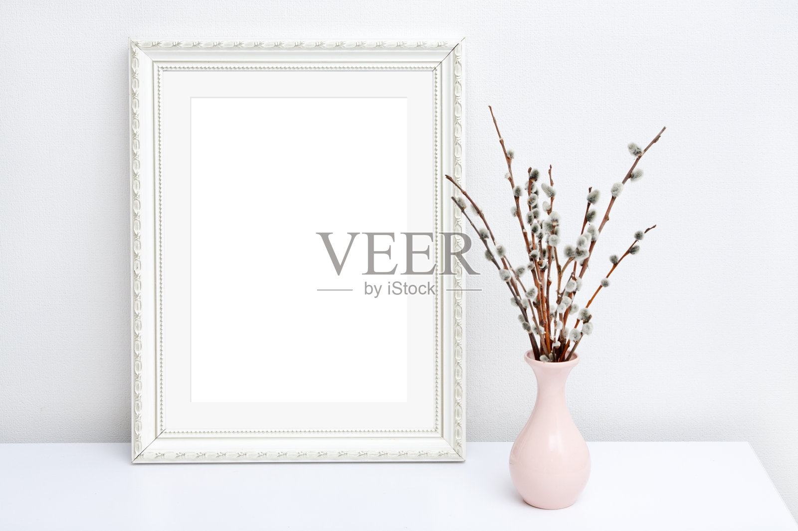 粉红色的花瓶与柳树和白色的框架与复制空间在白色的桌子上照片摄影图片