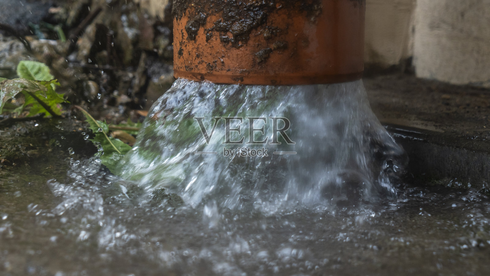 大雨。雨水从屋顶通过排水管流下。多雨的季节。照片摄影图片