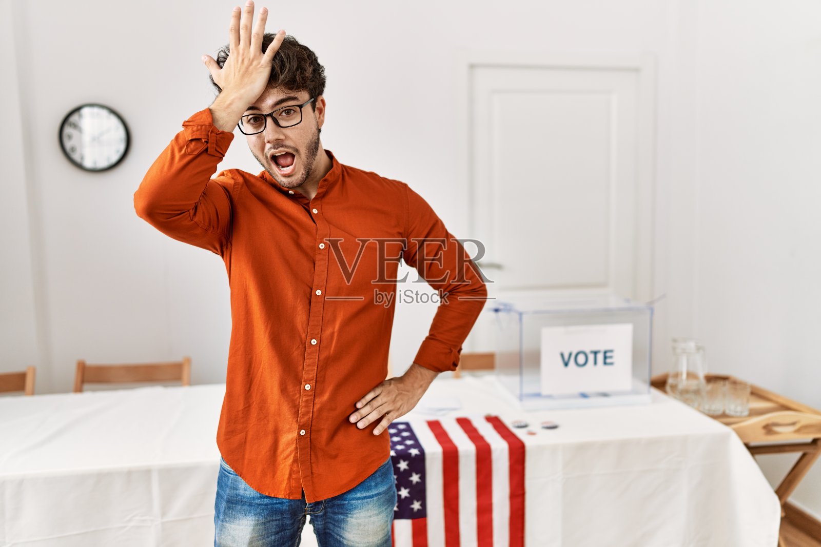 一名西班牙裔男子站在选举大厅里惊讶地发现自己犯了错误,记住错误。忘记,糟糕的记忆概念。照片摄影图片