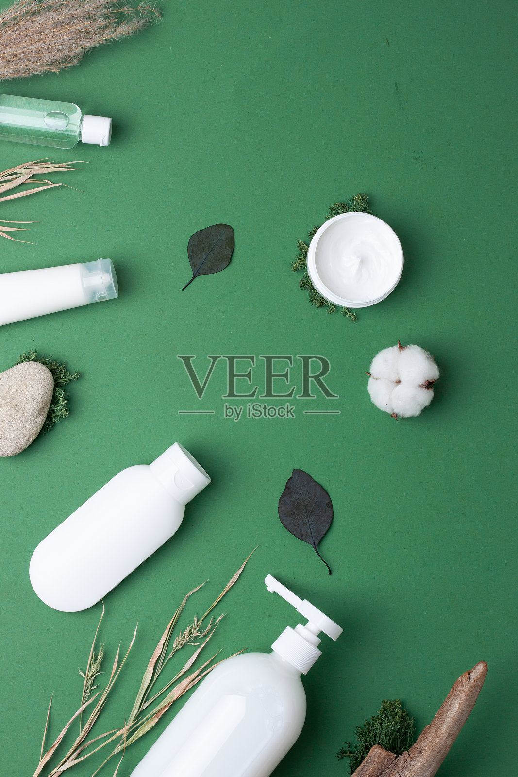 绿色背景上有花和木的化妆品护肤品。平躺照片摄影图片