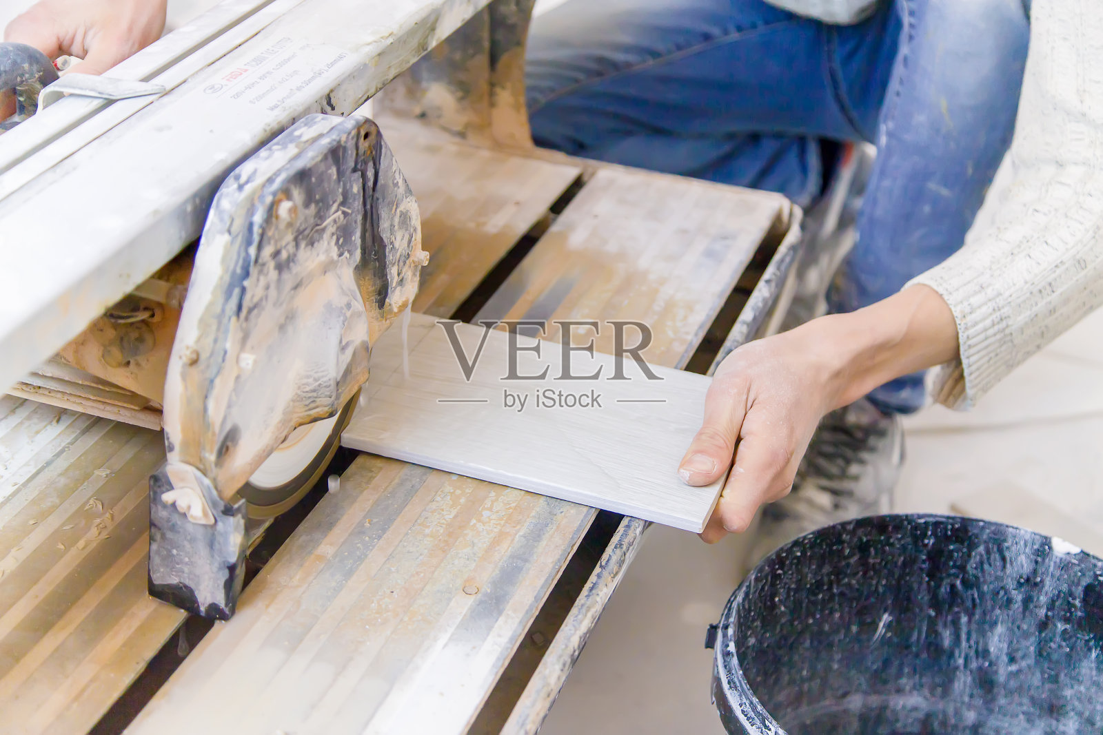 用切瓦刀修补房子里的瓦片。有选择性的重点。照片摄影图片