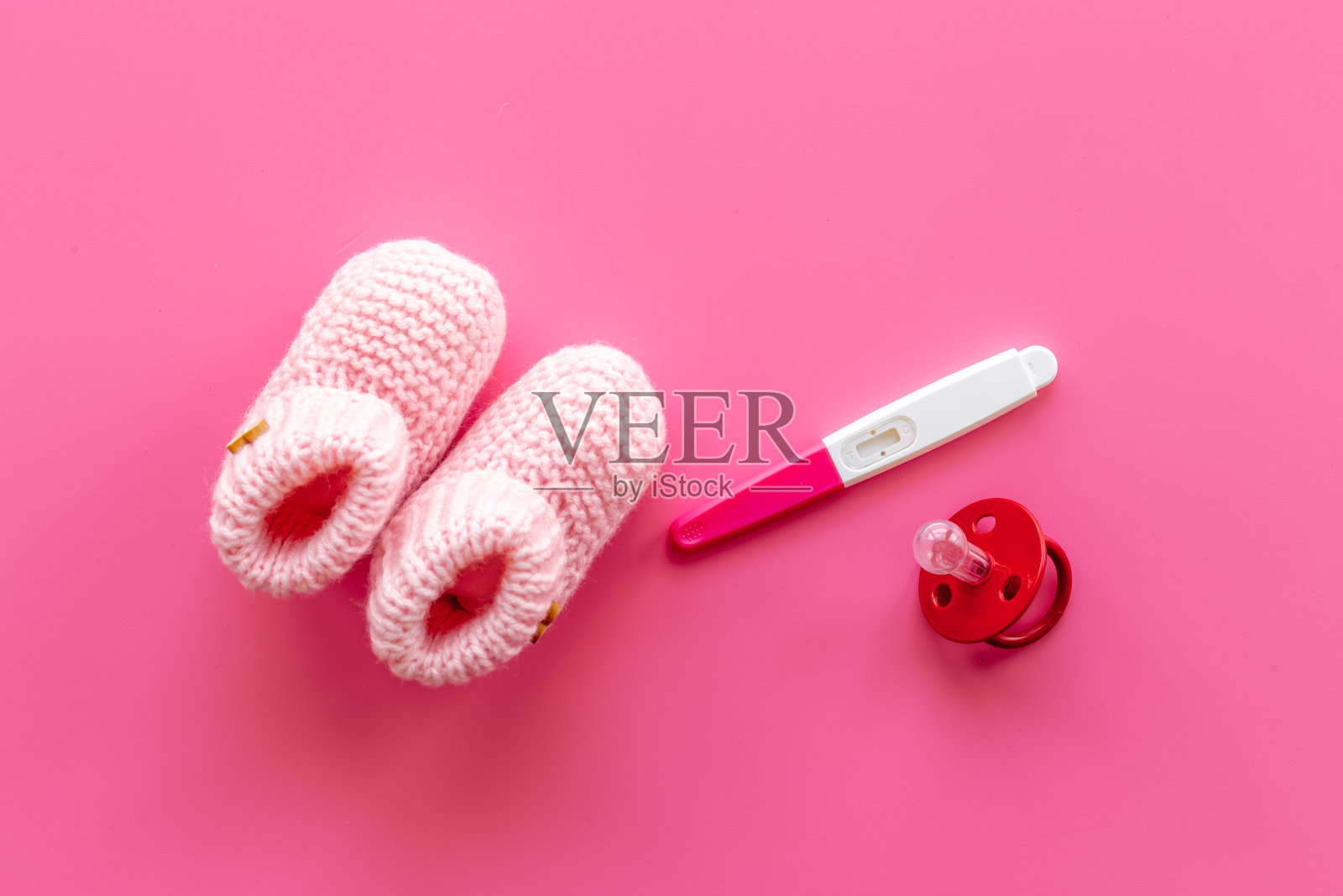 粉色的小女孩靴子上有验孕棒。怀孕和怀孕观念照片摄影图片