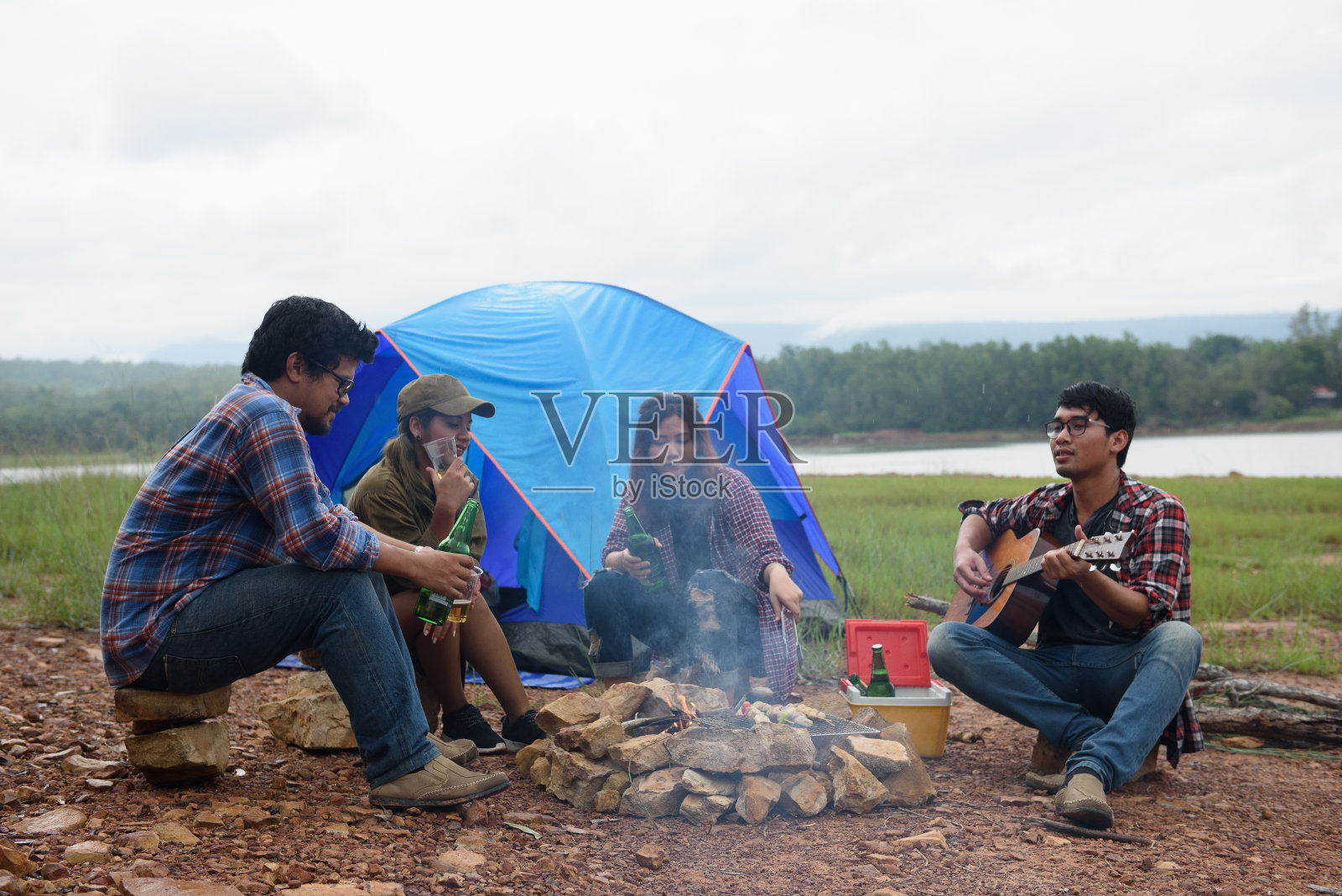 快乐的朋友们露营派对,在大自然和湖泊中演奏音乐,享受篝火,在露营中聚会,亚洲年轻人庆祝,旅游活动理念照片摄影图片
