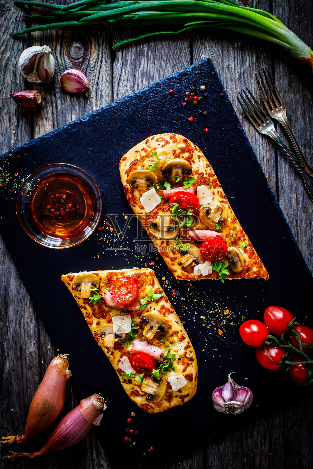 佛卡夏-烤马苏里拉奶酪三明治与意大利腊肠,白蘑菇和西红柿在黑色的石头盘照片摄影图片