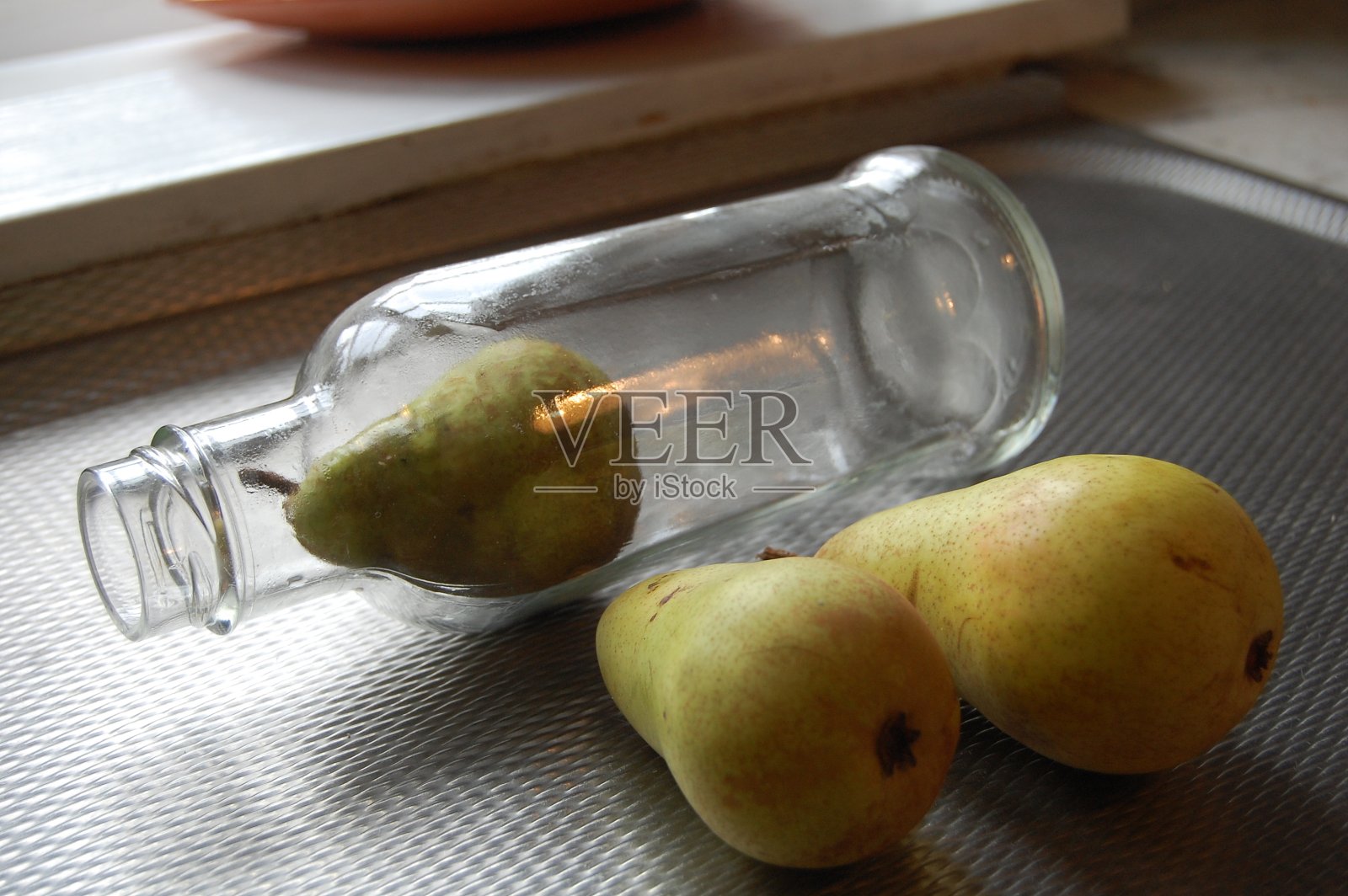 瓶子里的梨。照片摄影图片