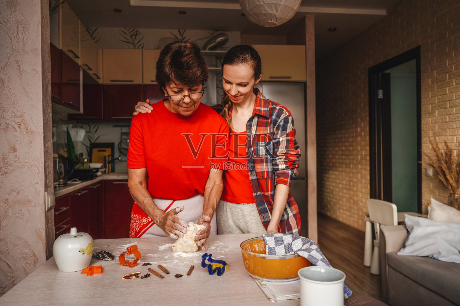 年轻女子和年长的母亲在做饼干。照片摄影图片