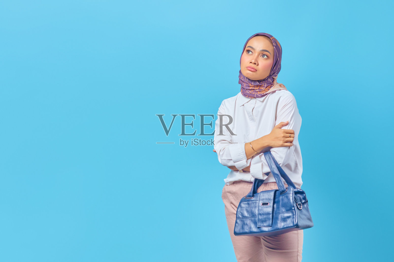 悲伤的亚洲女人的肖像拿着包看着空照片摄影图片