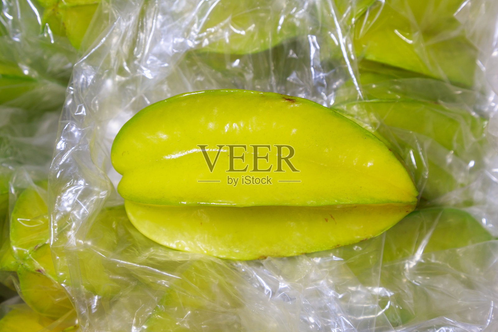 玻璃纸包装上的杨桃,特写镜头。杂货店货架上的产品。照片摄影图片