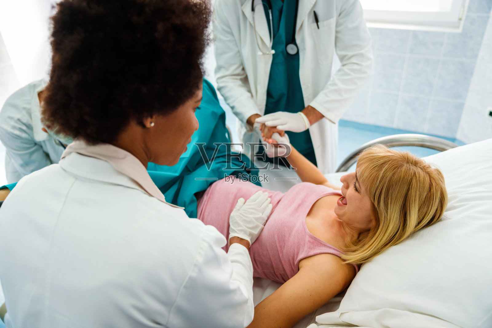 孕妇在医院努力分娩,妇产科医生协助照片摄影图片
