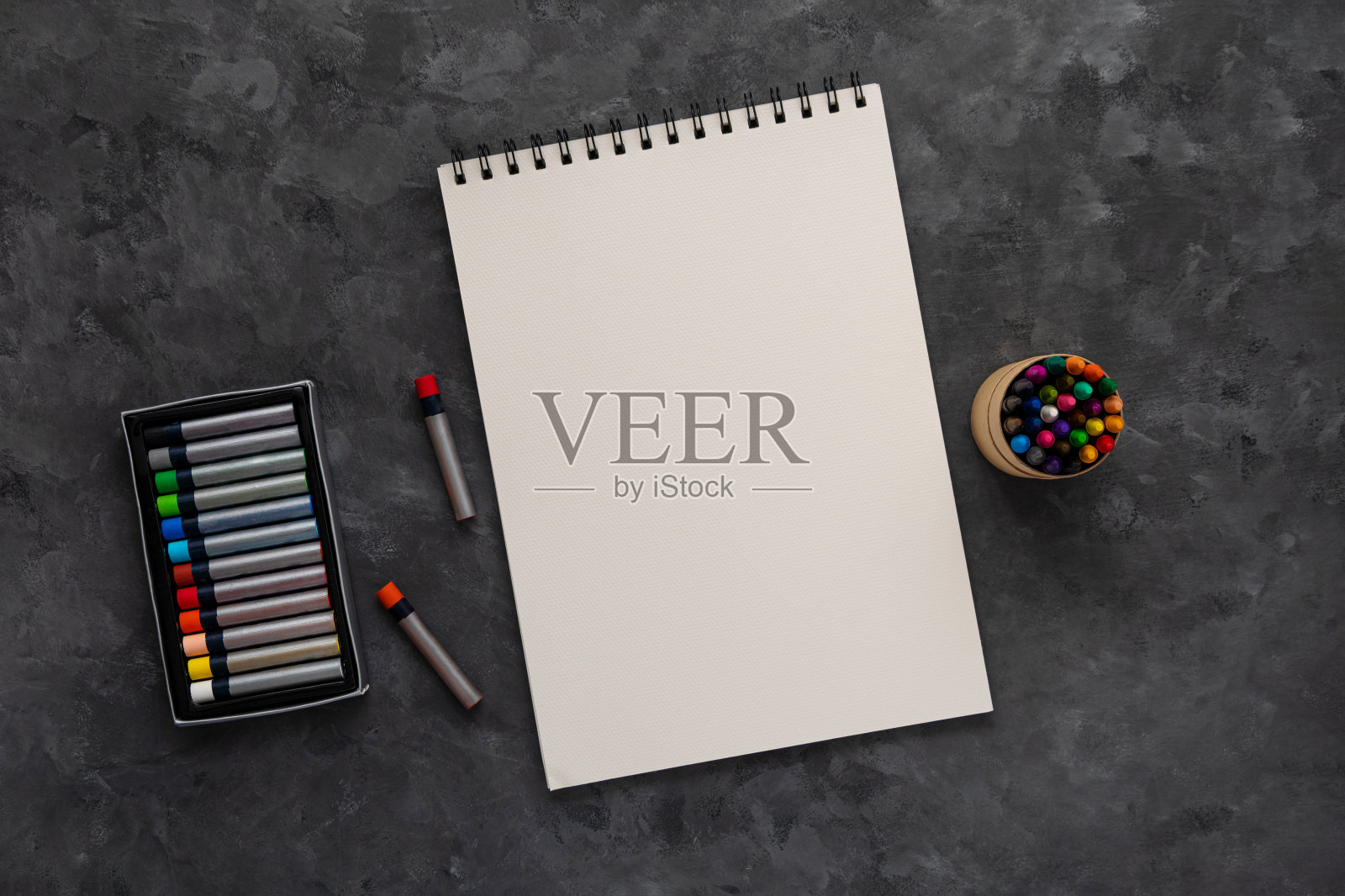 空白笔记本模型粉彩垫深色背景平铺。最小的工作空间写生本记事本模板,艺术绘画。照片摄影图片