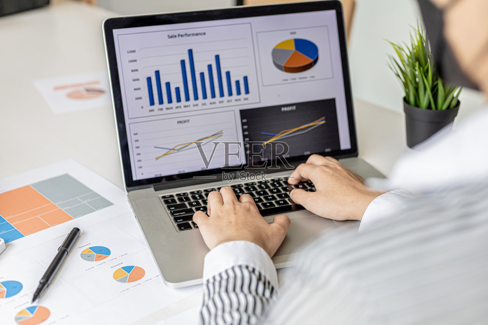 一位女商人正在用笔记本电脑键盘打字,她正在准备一份财务摘要,准备带去与商业伙伴的会议。公司财务管理理念。检查财务信息。照片摄影图片