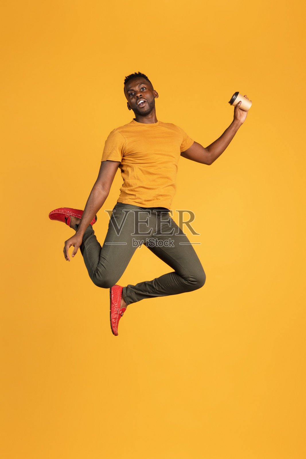身着休闲装的非洲青年肖像,孤立在黄色画室背景上。人类情感概念、面部表情、青春、感情、广告。照片摄影图片