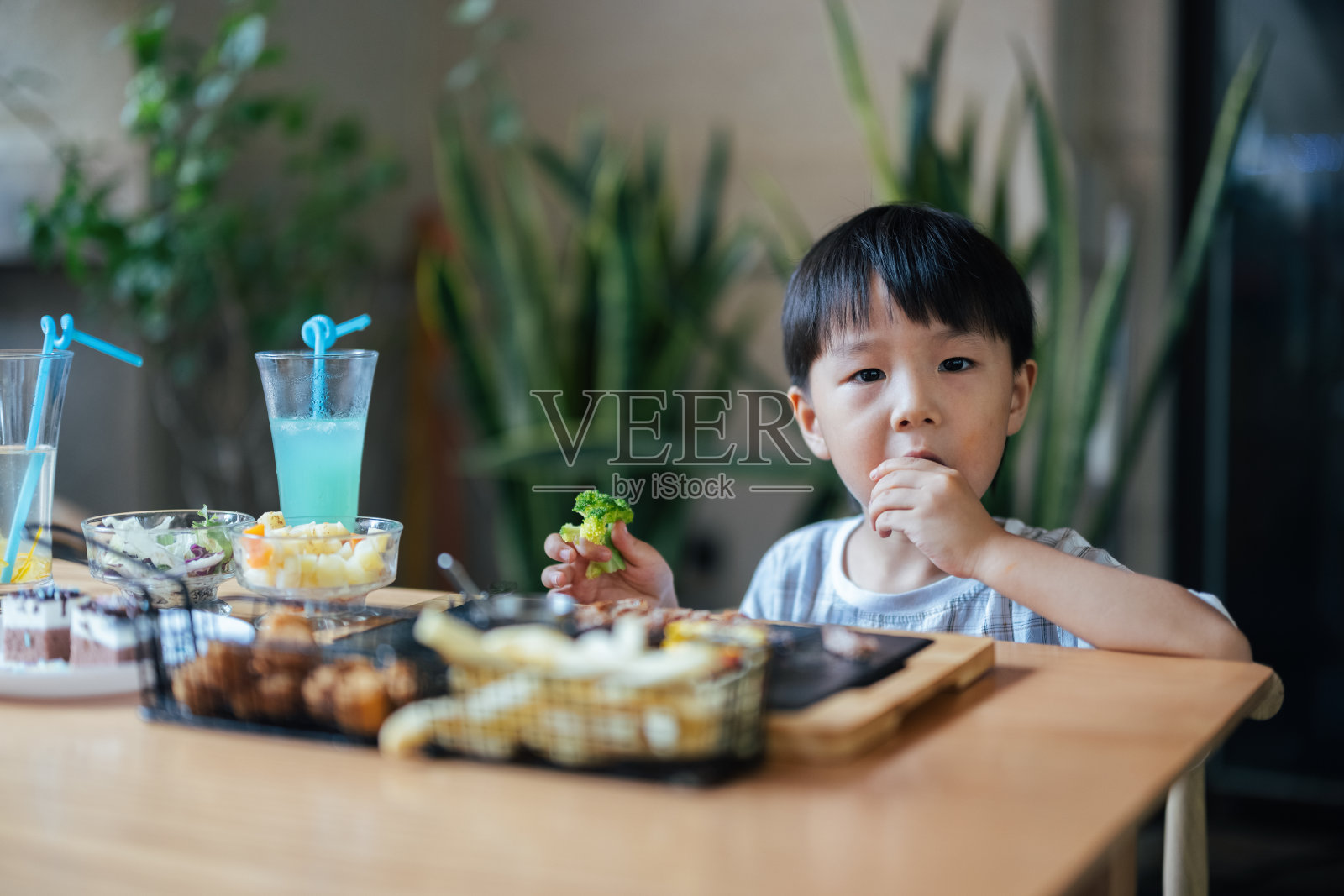 小男孩在餐馆吃饭照片摄影图片