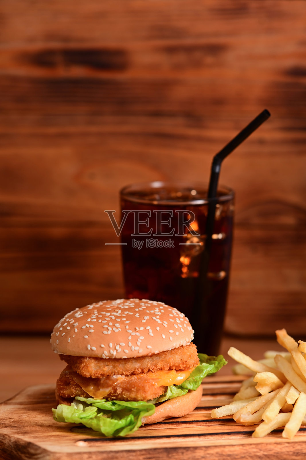 木桌上美味酥脆的自制炸鱼汉堡和炸土豆。照片摄影图片