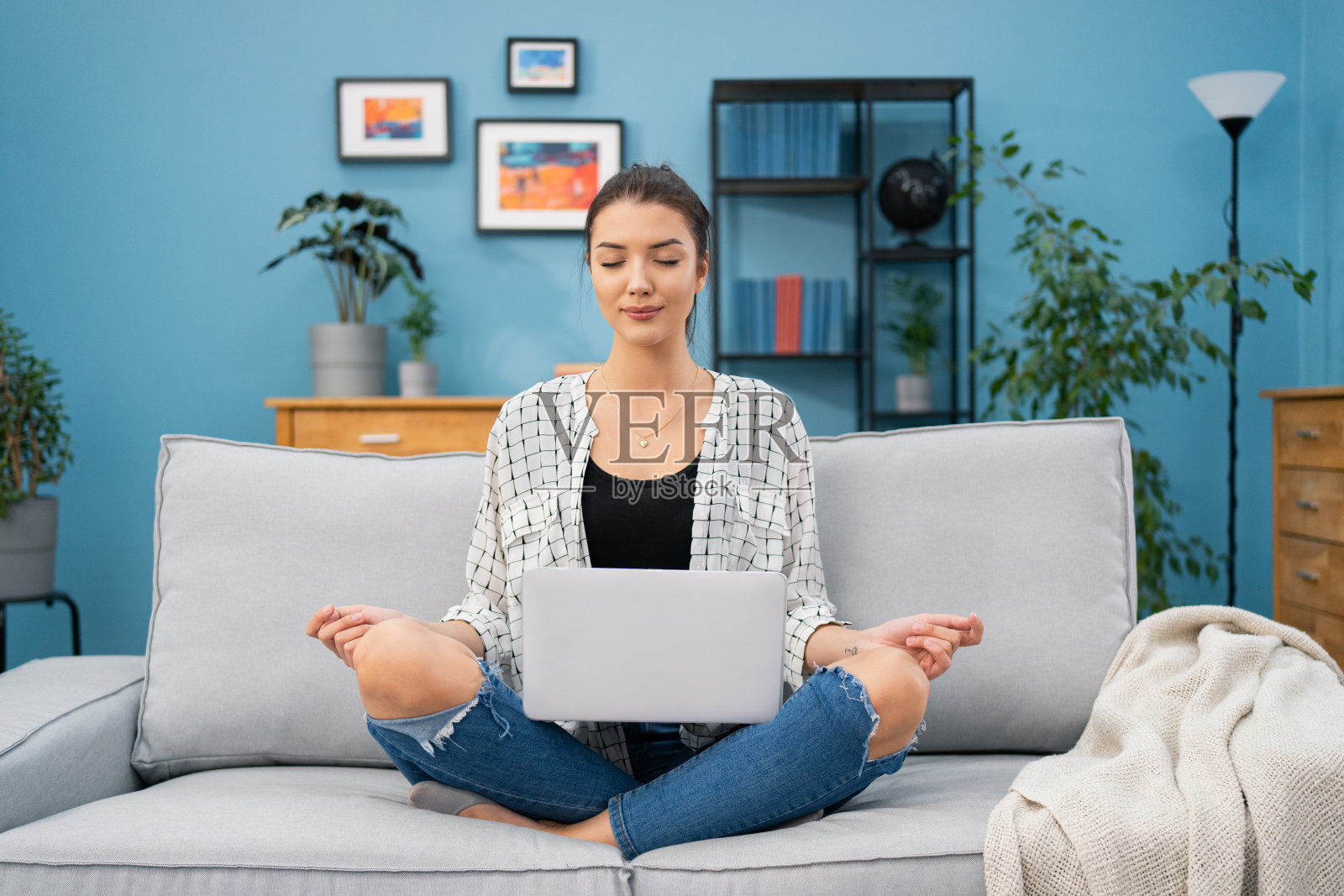 专注的女人微笑着放松休息在沙发上,每天冥想,膝上笔记本电脑放松音乐,女孩已经闭上眼睛和双手展开,肯定,积极思考,自我发展照片摄影图片