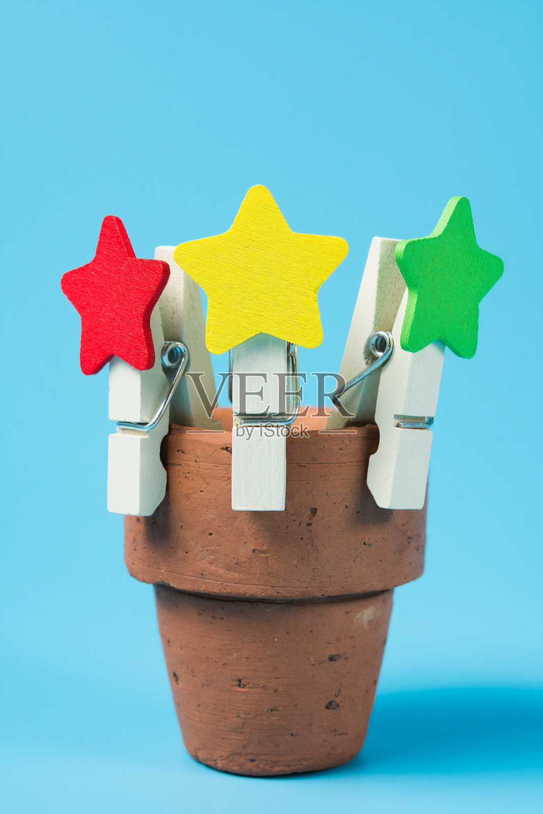 蓝色背景上的一套木制衣服别针。照片摄影图片