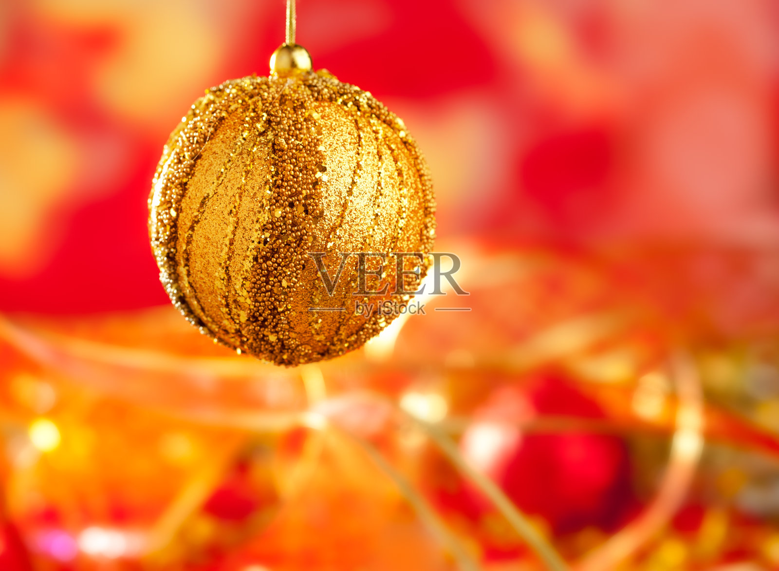 金色小玩意和红色模糊的圣诞卡照片摄影图片