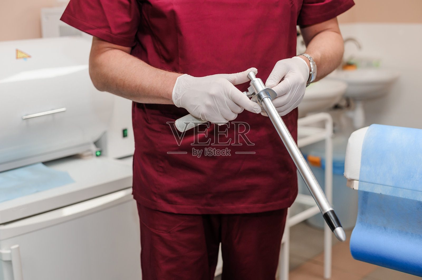 医生手里拿着环形灯的肛门镜。可重用的直肠病学仪器照片摄影图片