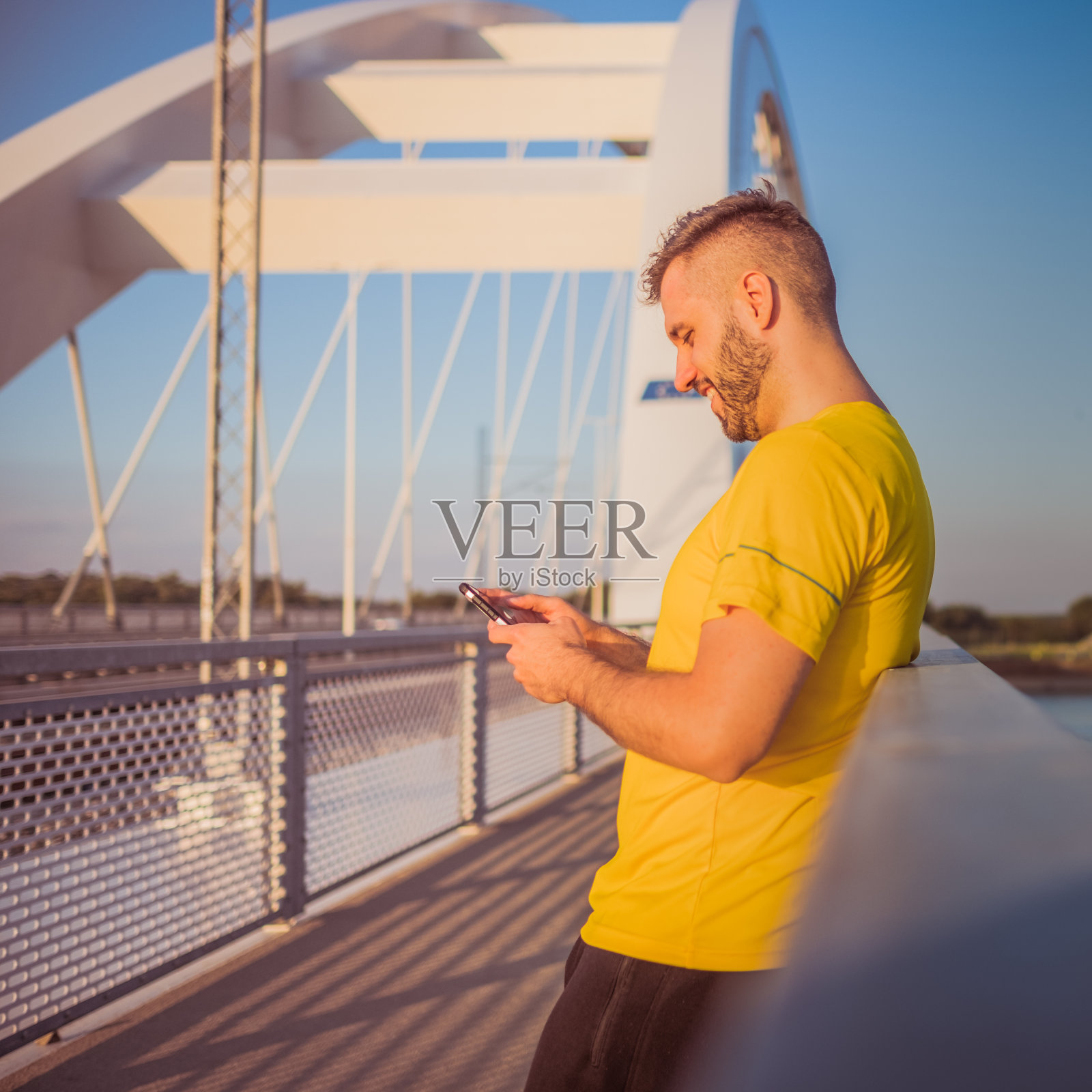 年轻的运动员微笑着打电话照片摄影图片