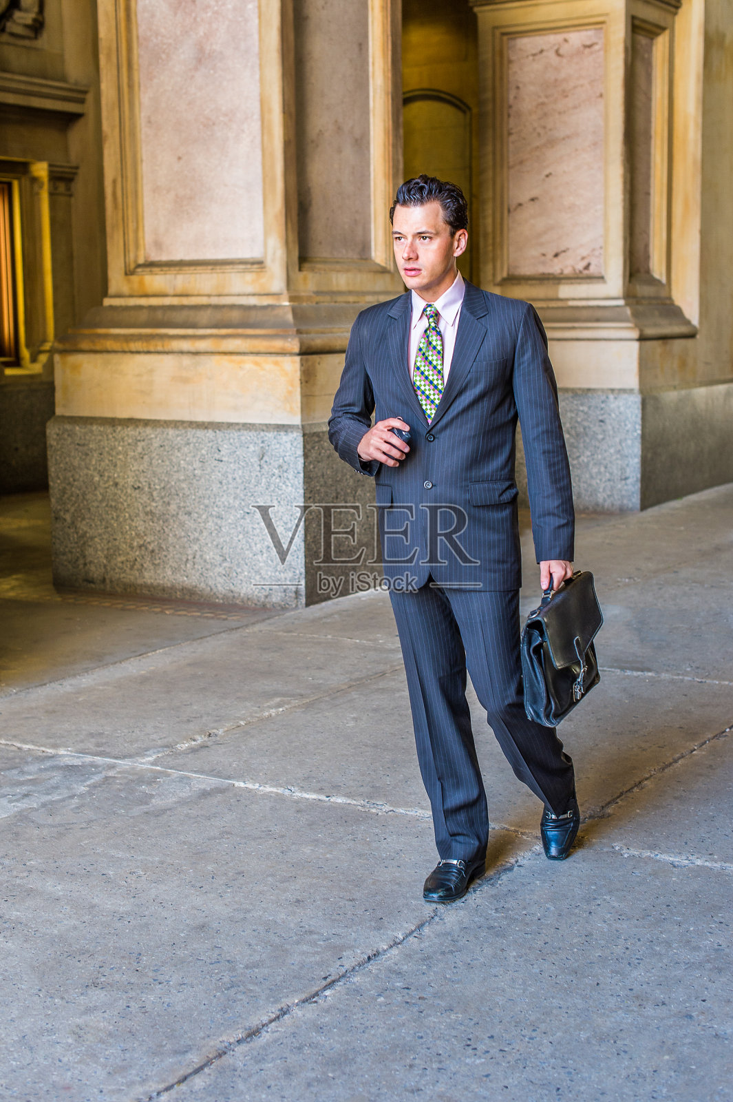 年轻的商人走在办公楼外面照片摄影图片