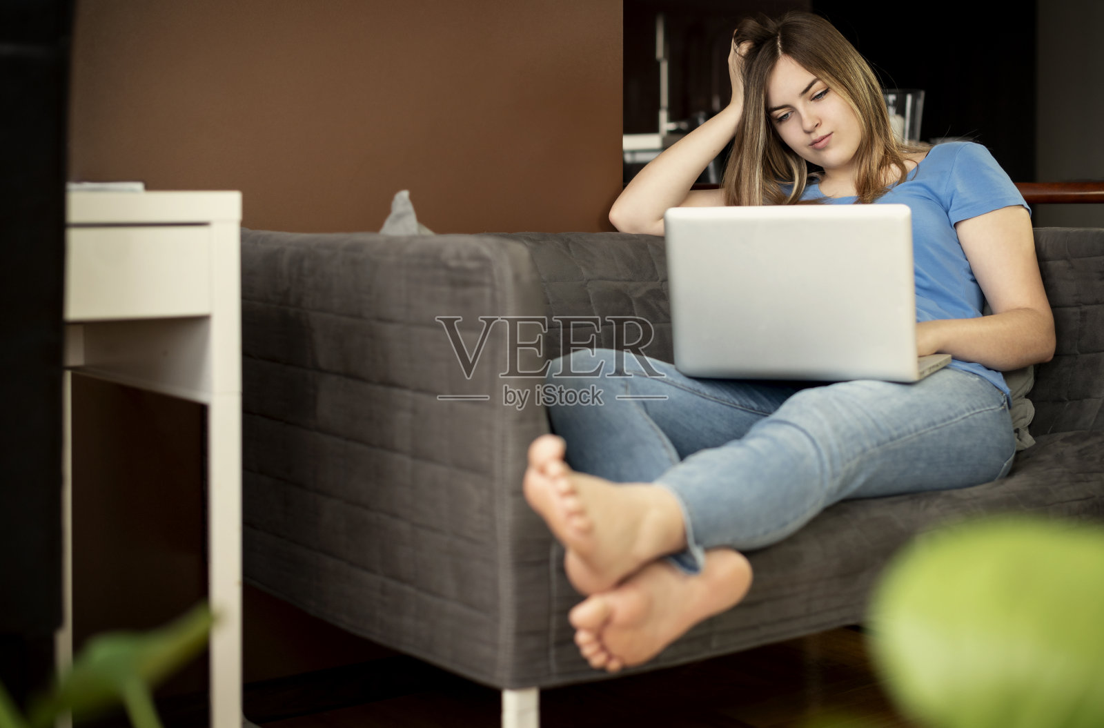 微笑美丽的年轻女子在家里使用电脑。照片摄影图片