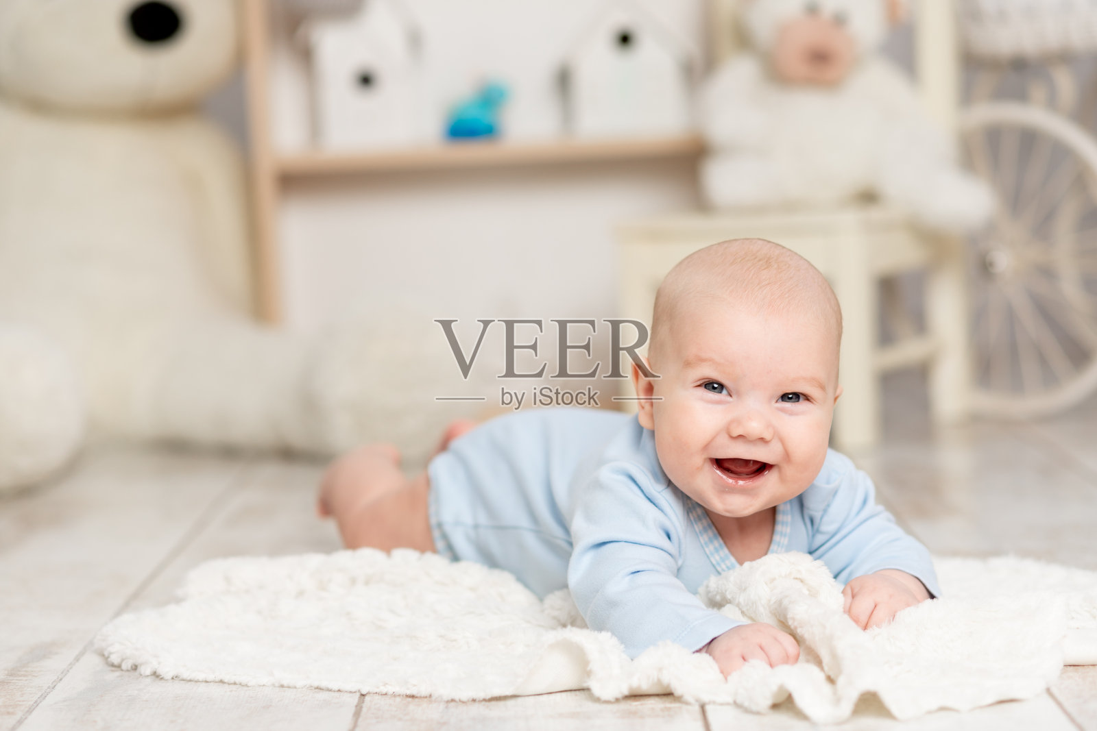 笑宝宝躺在家里的孩子的房间里,带着玩具、发展理念和游戏照片摄影图片