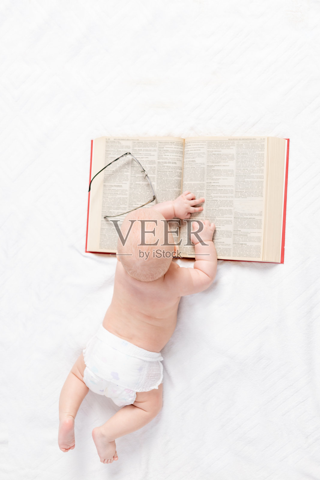 一个婴儿拿着一本书,俯视图,培养和发展观念照片摄影图片